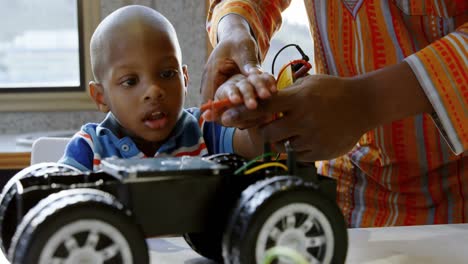 father and son repairing toy car in a comfortable home 4k