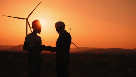 wind turbine engineers discussing at sunset