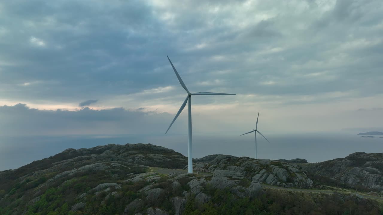 Scenic wind turbine park producing renewable energy along Norwegian coastline.
