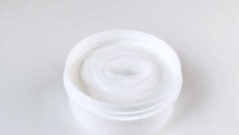 le dita prendono la crema dal barattolo
