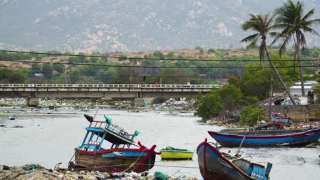 abandoned fishing boats and piles of trash in riverbed in son hai, vietnam