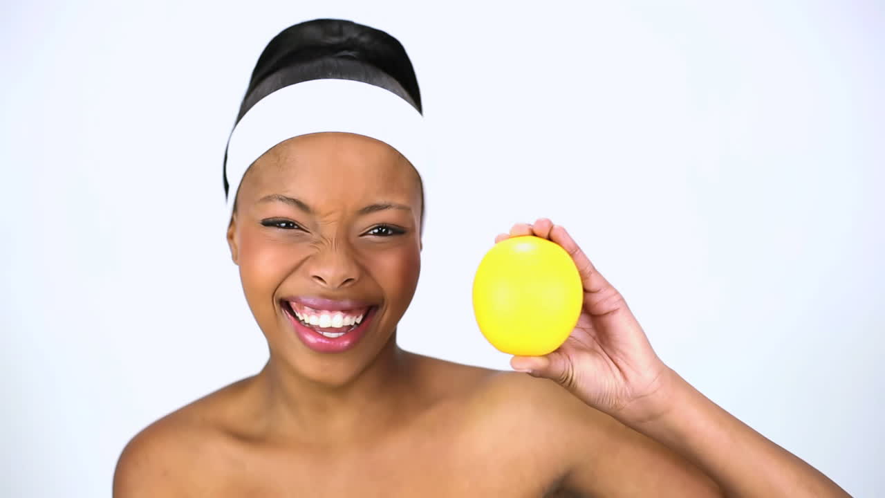 Mulher sorridente segurando uma laranja