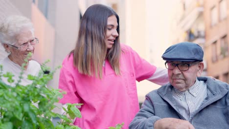 Caregiver assisting elderly people in a garden