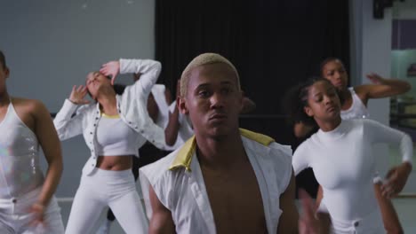 grupo multiétnico de bailarines modernos hombres y mujeres en forma practicando una rutina de baile