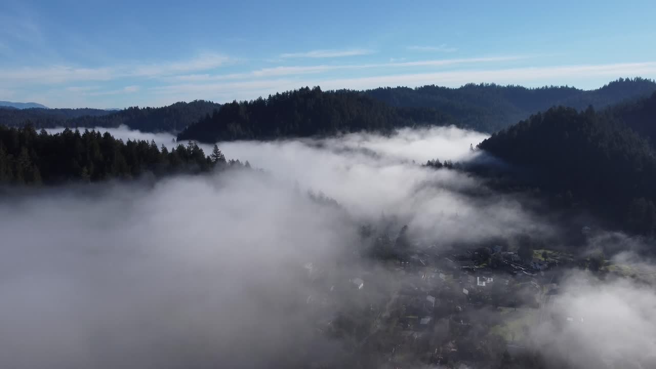 구불구불한 언덕을 둘러싼 구름 위를 날다