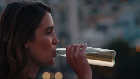 retrato de una hermosa mujer joven bebiendo alcohol disfrutando de la vista de la azotea del horizonte de la ciudad al atardecer sonriendo feliz el fin de semana