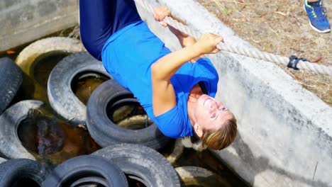 mujer cruzando la cuerda durante el curso de obstáculos 4k