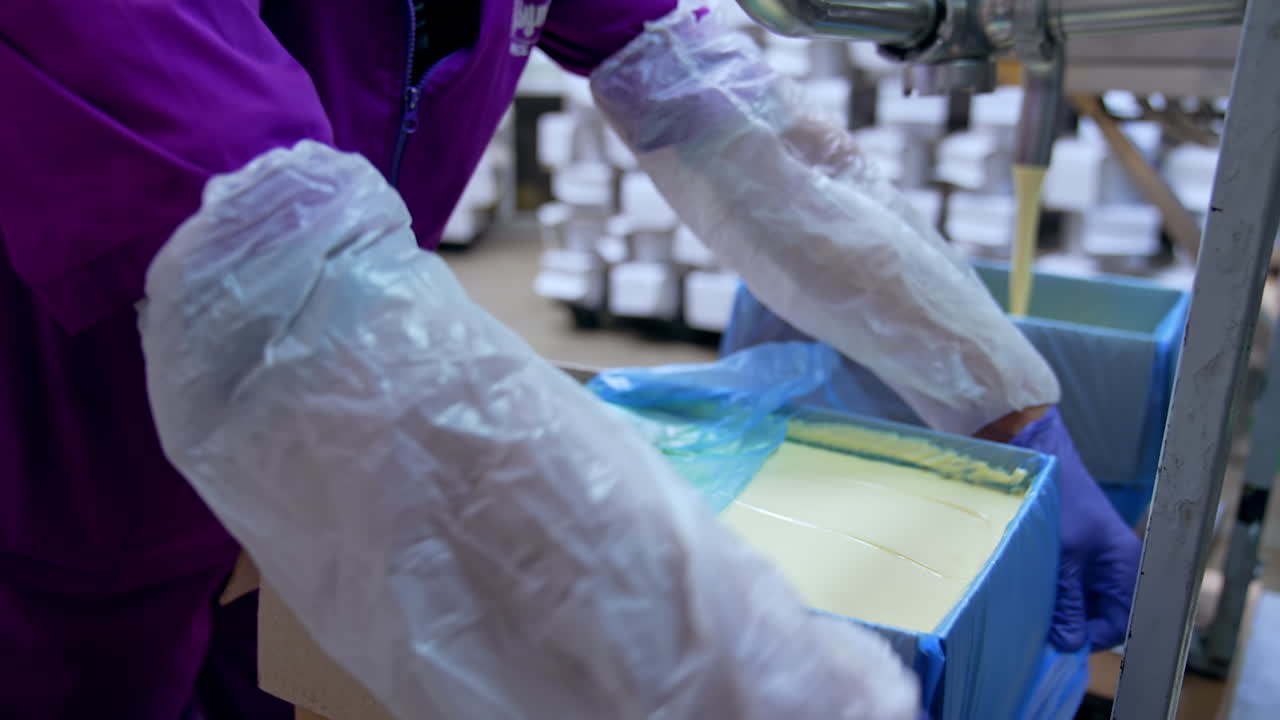 Filling of butter container. Butter poured into box at the creamery
