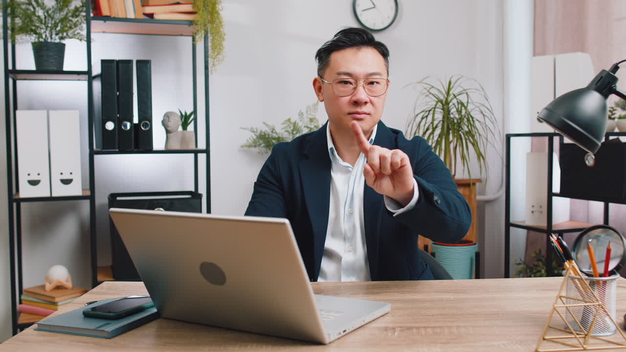 Business man working on laptop shakes finger saying no be careful giving advice to avoid mistake