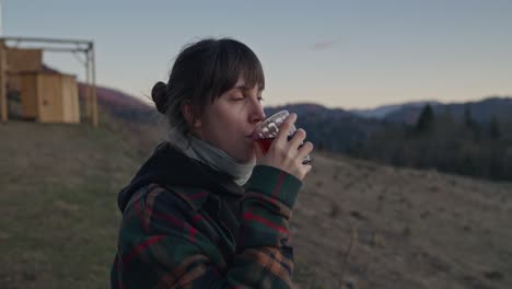 mujer disfrutando de una bebida en las montañas