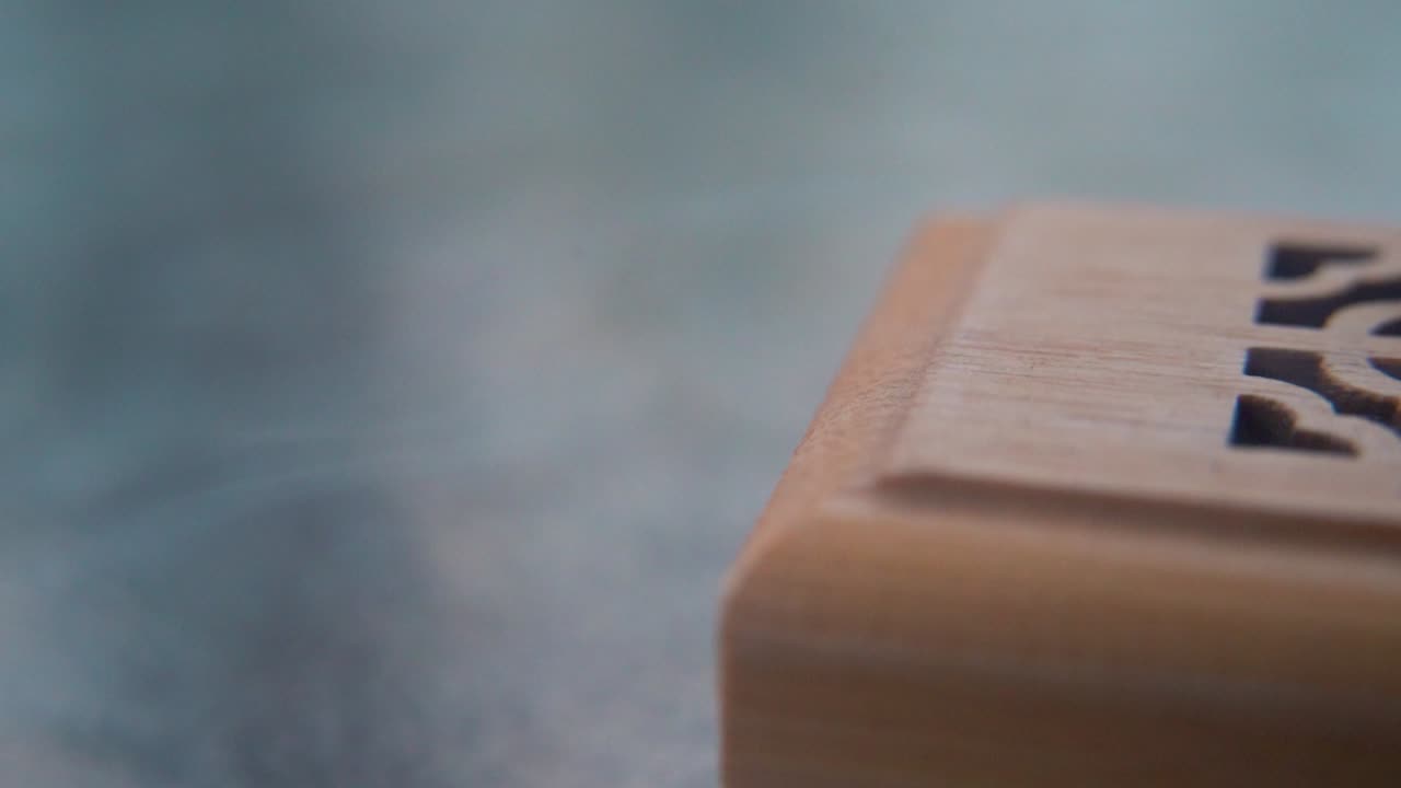 A close-up macro shot of smoking incense in a wooden box, spiritual ritual meditation, scented therapy fragrance, relaxing aromatic white smoke, textured case, smooth slowmotion video 120fps pan right