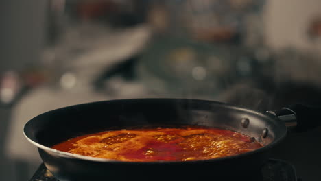 chicken in tomato sauce is boiling on a frying pan with spices. cooking tomato sauce curry with chicken fillet. traditional italian mexican asian dish. high quality studio shot for cafe, restaurant close up.