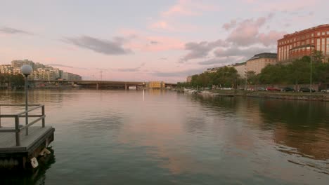 calm waters over the harbour of helsinki with pink skies overhead reflecting in the waters below.