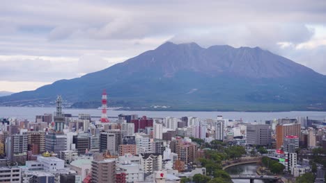 kagoshima city with sakurajima smoking from eruption in the background