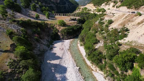 rama prístina del río de vjosa que fluye a través de los acantilados, antiguo acueducto construido a orillas del río, albania