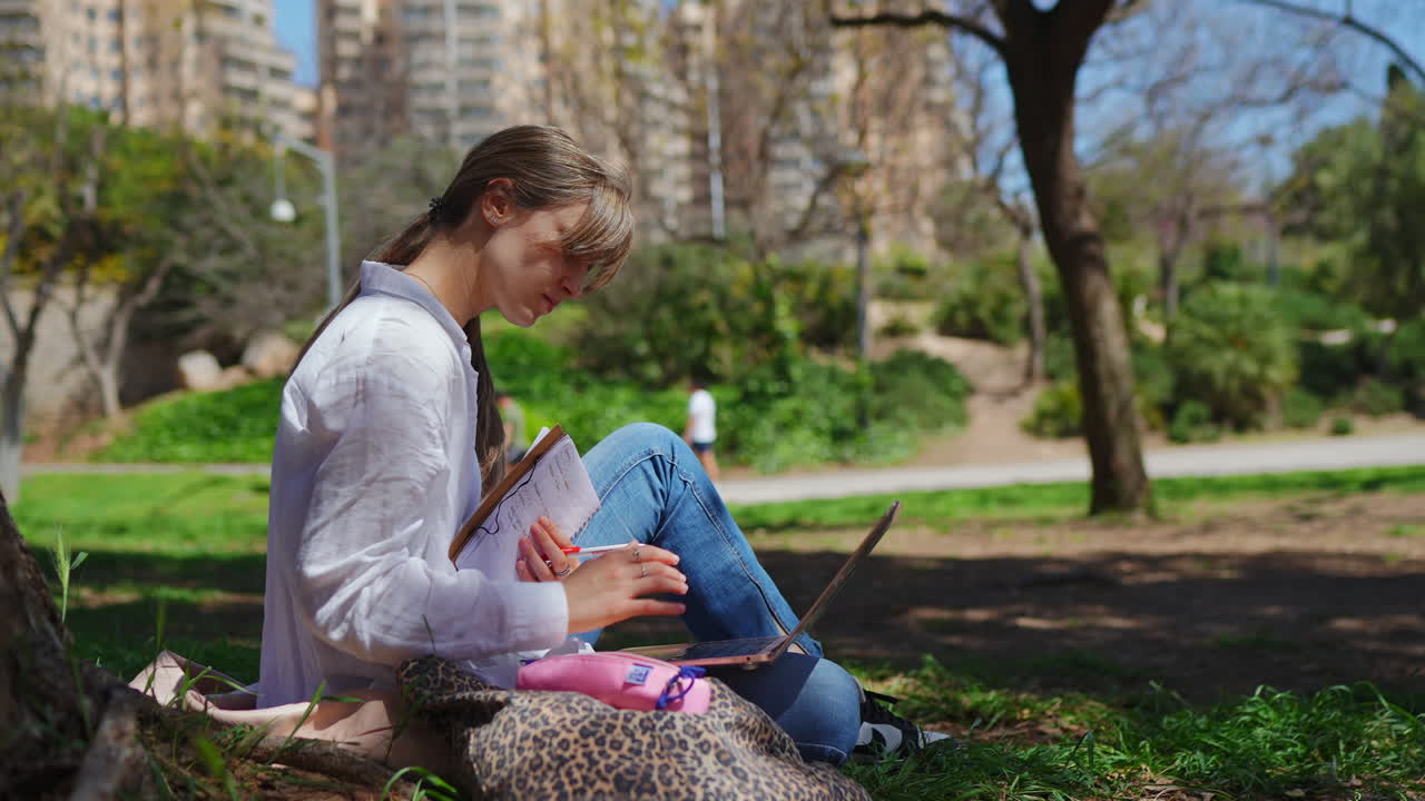mujer trabajando en computadora portátil en el parque