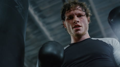 Angry-kickboxer-looking-at-camera-at-gym.-Sportsman-showing-anger-in-sport-club