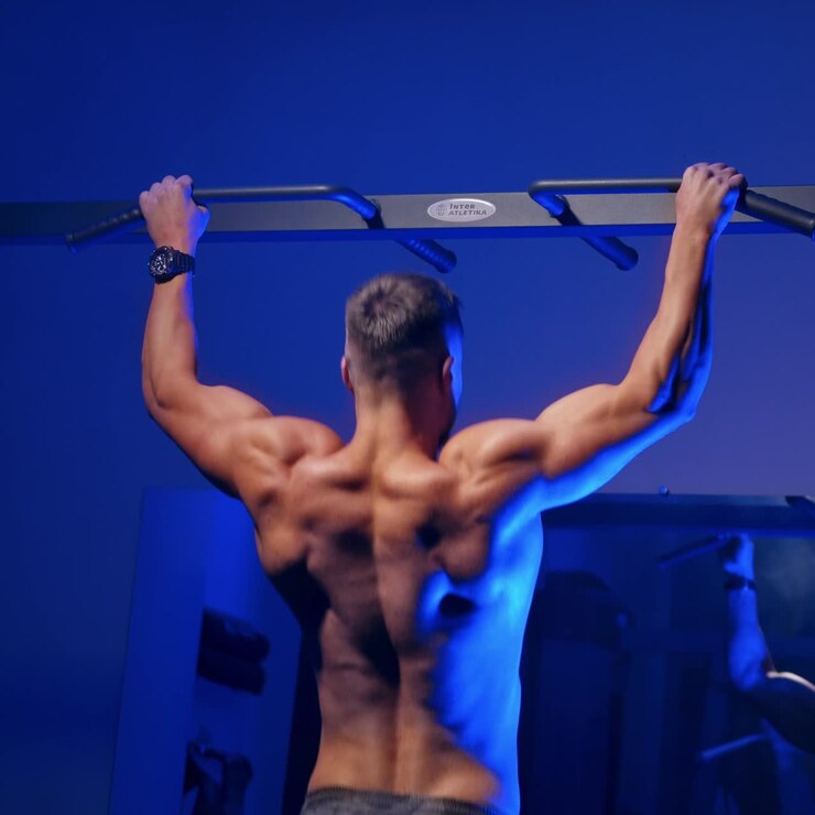 Man training on horizontal bar in gym