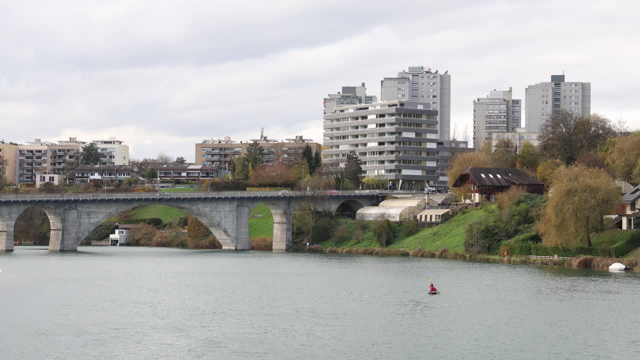 Person in a kayak paddling down the river in a city, establisher