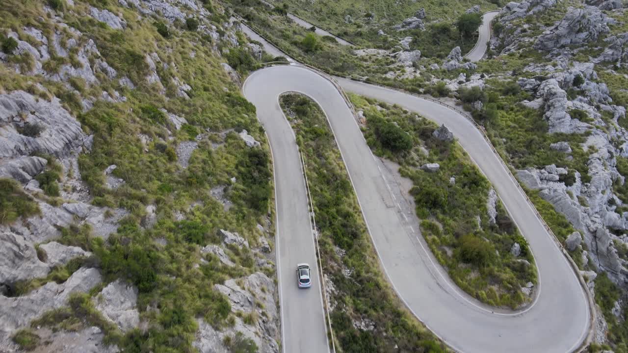 siguiente coche en una sinuosa carretera de montaña con curvas cerradas en un día soleado en sa calobra, mallorca, españa