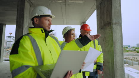 Bauingenieure-Besichtigen-Die-Baustelle.-Zwei-Männer-Und-Eine-Junge-Frau-Besprechen-Den-Bauplan