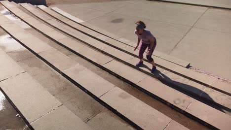 a shot focused on a redhead woman jumping some bleachers in a park