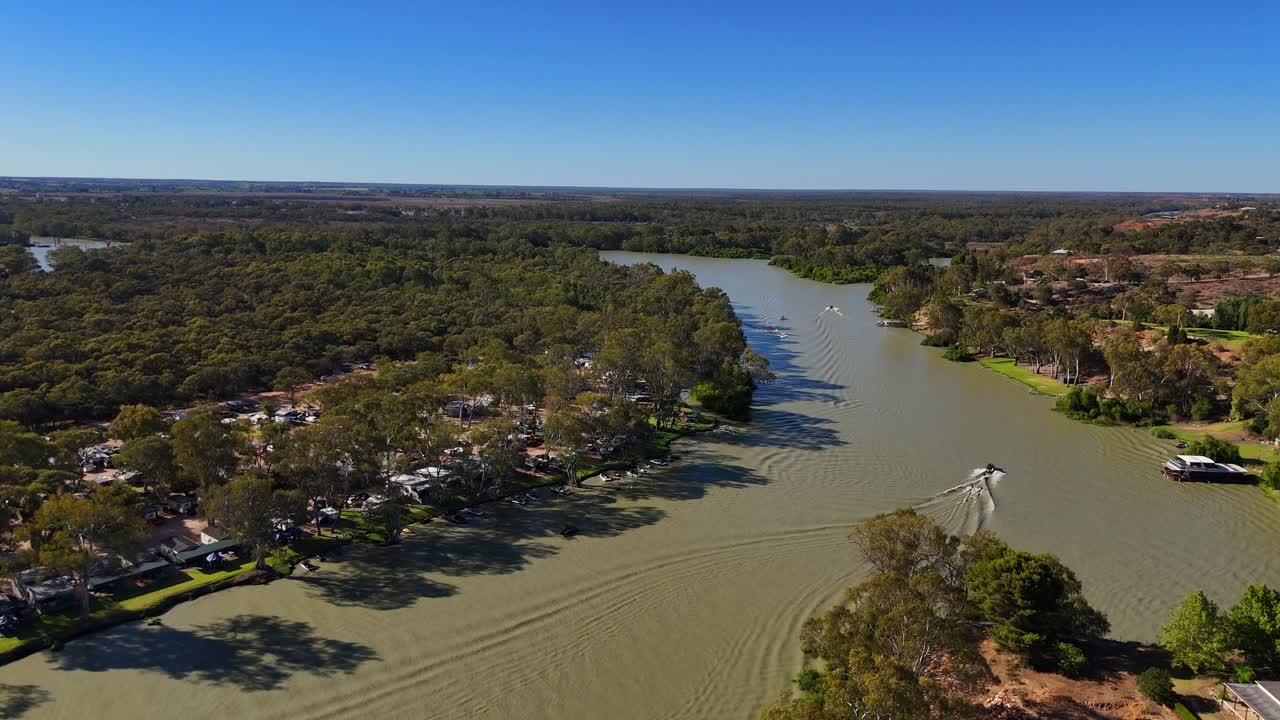 Die Stadt Paringa am Murray River mit verstreuten Gebäuden, Grünflächen und einem sich windenden Wasserlauf, mittlere Luftaufnahme