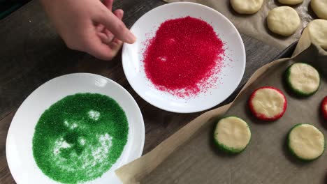 Mano-Haciendo-Galletas-De-Azúcar-Navideñas-Bordes-Rodantes-Con-Chispitas-Rojas-Y-Verdes