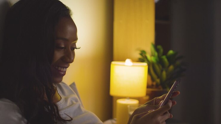 Primo piano di coppia che si rilassa a casa di notte a letto guardando il cellulare insieme