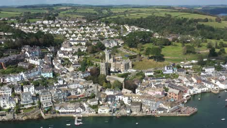 wide rising aerial view of fowey parish church, and porphry hall in the town of fowey, cornwall, uk