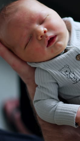 sleeping newborn baby in parent's arms