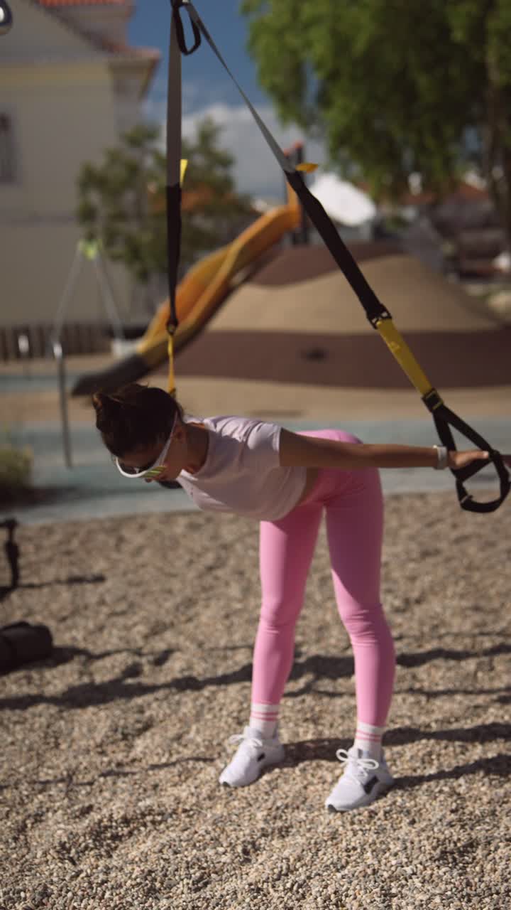 Woman Working Out Outdoors with TRX Suspension Trainer