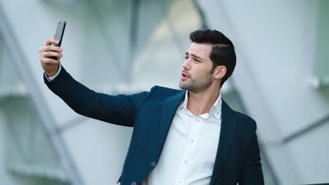 Portrait-male-entrepreneur-taking-selfie-photo-on-mobile-phone-at-city-street