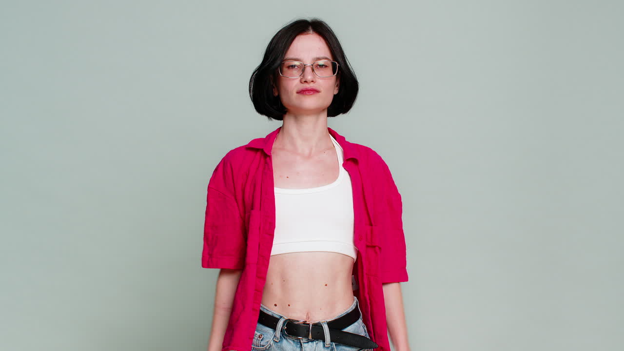 Woman shows thumbs down with serious expression expressing dislike disagreement or disappointment