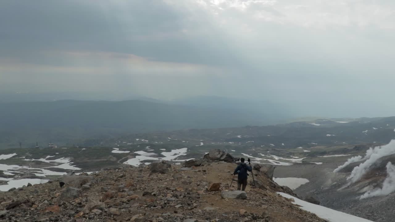 아사히산의 바위산 경사면을 내려가는 고독한 남성 모험가