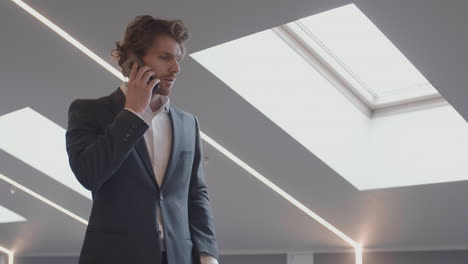 red-haired businessman making phone call in office