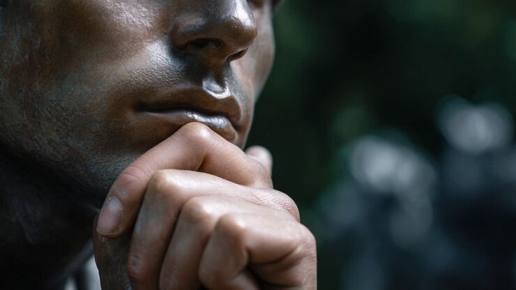 Thoughtful bronze sculpture depicting a contemplative figure with a hand on chin, capturing the essence of deep reflection and human emotion in art