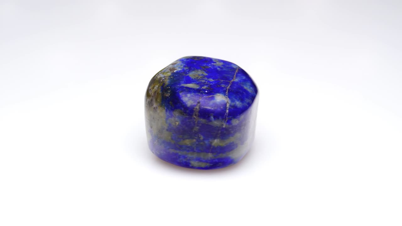 piedra preciosa natural de lapis lazuli en el fondo blanco en la mesa de giro