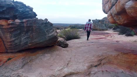 hombre caminando a través de las formaciones rocosas 4k