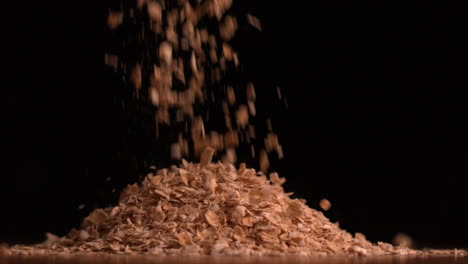 cereal flakes pouring on black background