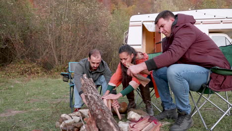 Couple-and-their-close-friend-preparing-camp-fire