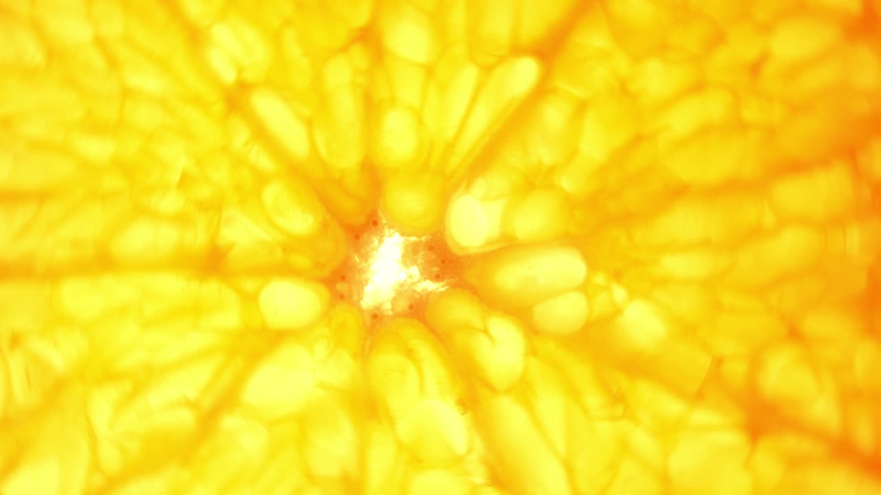 Vista dall'alto, rotazione di una fetta d'arancia su sfondo bianco, primo piano, sfondo astratto con fette d'arancia trasparenti