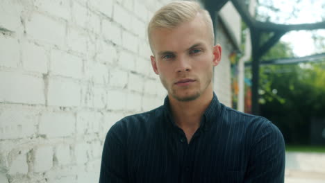 young man portrait against a brick wall