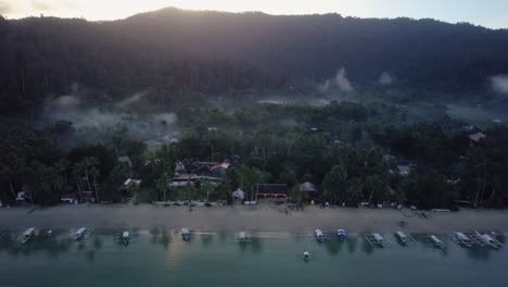 Aerial-of-calm-fishing-village-at-beautiful-misty-daybreak-in-the-Philippines---backwards-tracking-shot