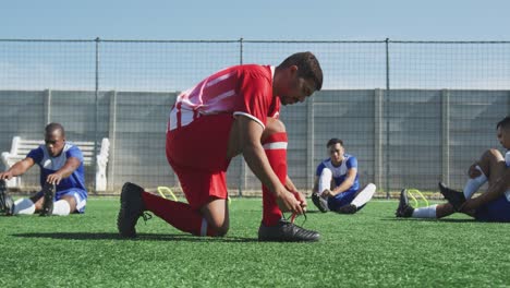 Soccer-players-tying-his-shoes-on-field