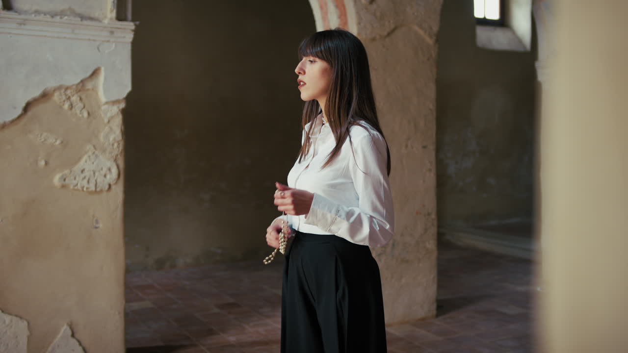 Woman Praying In Devotion With A Rosary In The Hands Inside A Church