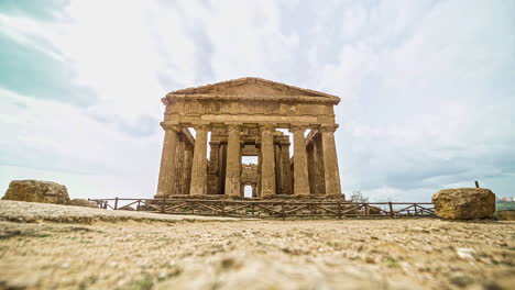 Tiro-De-ángulo-Loa-Del-Templo-De-La-Concordia-En-El-Valle-Del-Templo,-Agrigento,-Italia-Con-Movimiento-De-Turistas-Con-Movimiento-De-Nubes-En-Timelapse