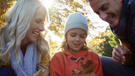 mother-dad-and-daughter-playing-with-leaves-outdoors