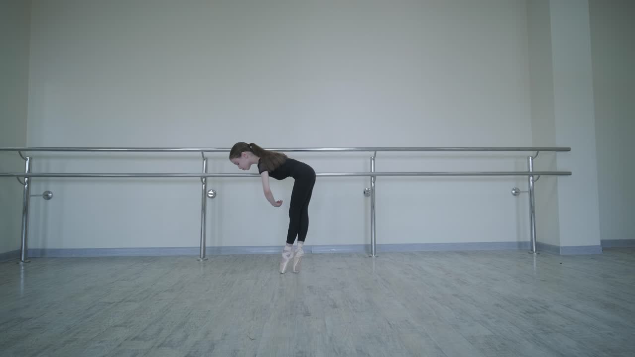 Giovane ballerina che pratica passi di danza in studio