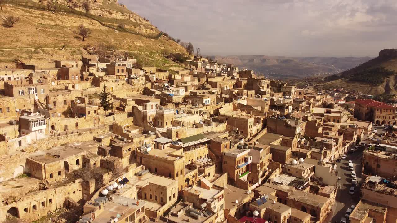 Ripresa aerea con drone della città vecchia di Mardin, Turchia, adagiata su una collina, con densi edifici in pietra e strade a più livelli, un paesaggio urbano storico, patrimonio culturale e destinazione di viaggio.